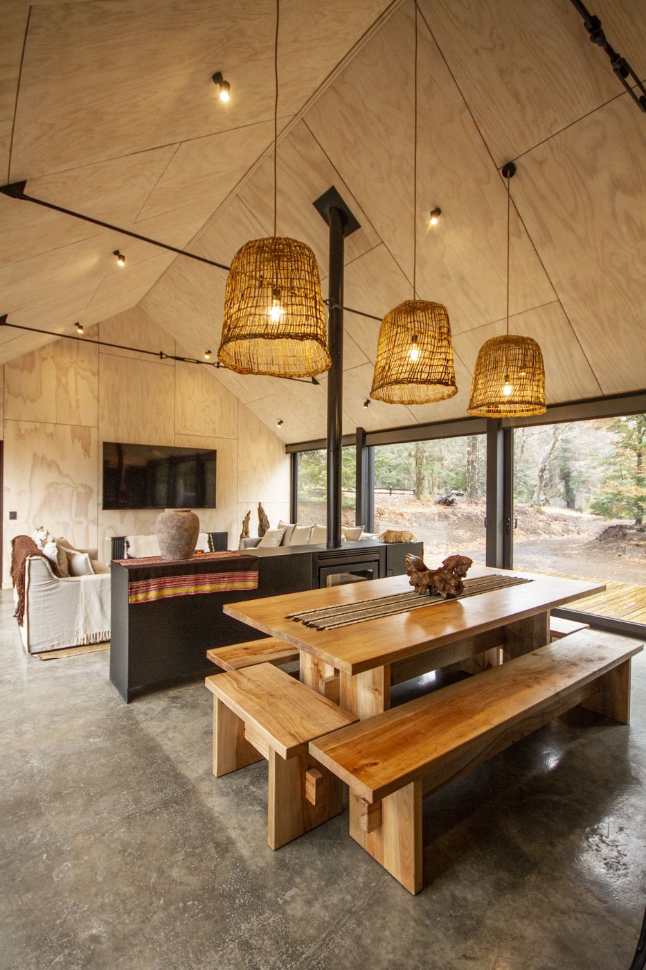 Interior de la casa Malalcahuello con cielo de madera, comedor y lámparas de fibra